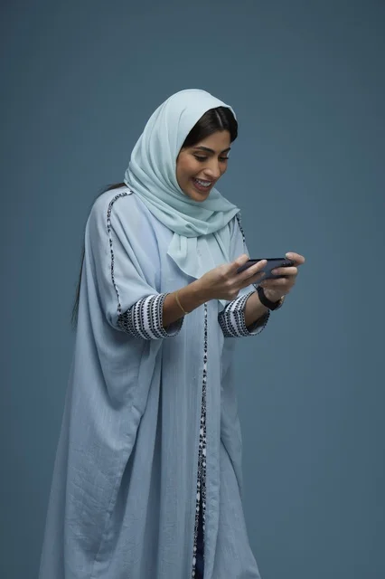 Saudi Woman Using Smartphone with Smile in Abaya