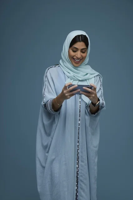 Saudi Woman in Abaya Using Smartphone with a Smile