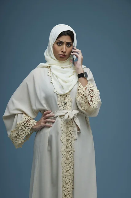 امرأة سعودية بعباءة تتحدث بالهاتف الذكي