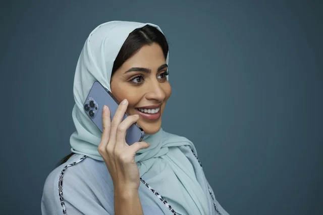 امرأة سعودية محجبة تتحدث عبر الهاتف الذكي في الاستوديو