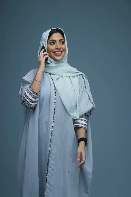 امرأة سعودية محجبة تتحدث عبر الهاتف الذكي في استوديو