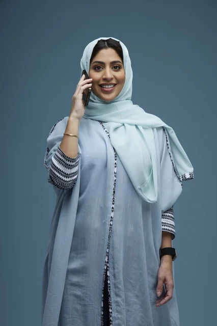 امرأة سعودية محجبة تتحدث عبر الهاتف الذكي
