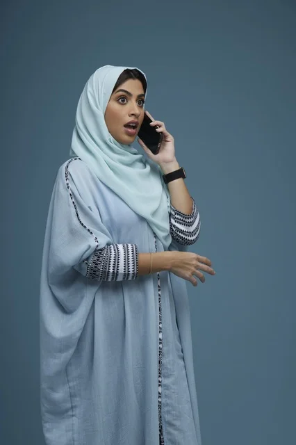 Surprised Saudi Woman in Hijab Talking on Smartphone