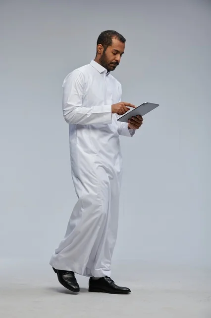 Saudi Man in White Thobe Using Tablet in Studio