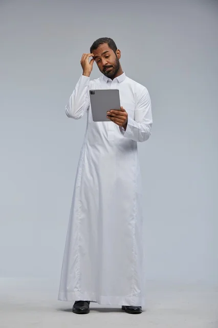 Saudi Man in White Thobe Using Tablet with Confused Look