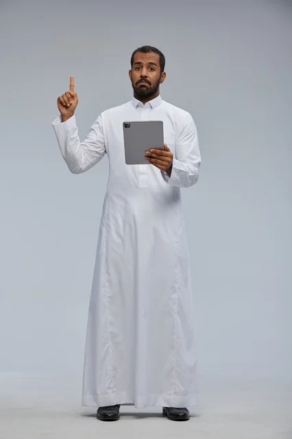 Saudi Man in White Thobe Holding Tablet