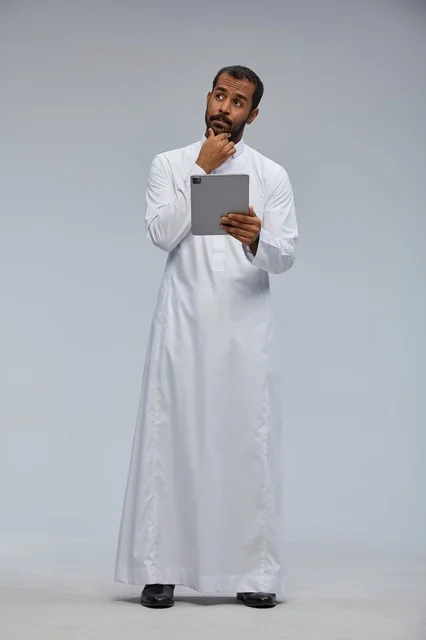 رجل سعودي بالثوب الأبيض يحمل جهازاً لوحياً