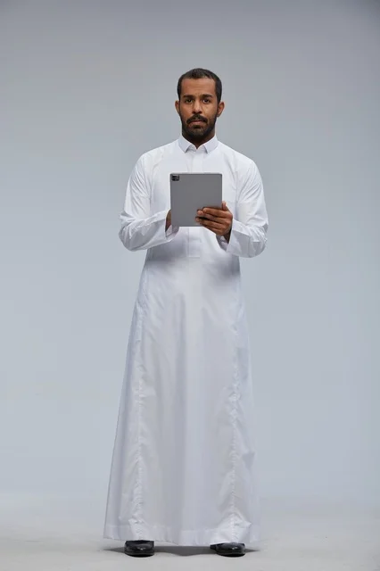 Saudi Man in White Thobe Using Tablet in Studio