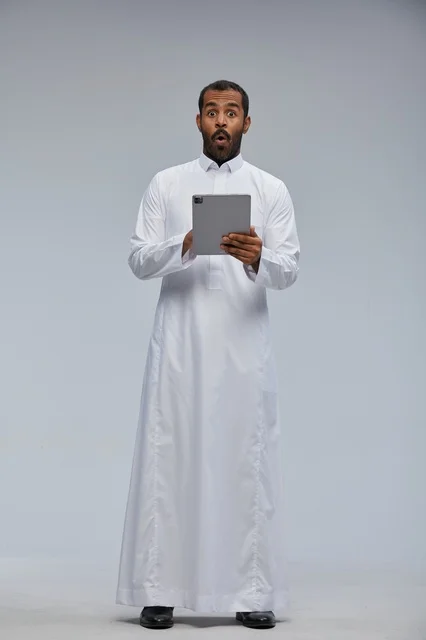 Saudi Man in White Thobe Holding Tablet Shocked Expression