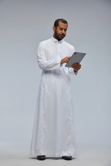 Saudi Man in White Thobe Using Tablet in Studio