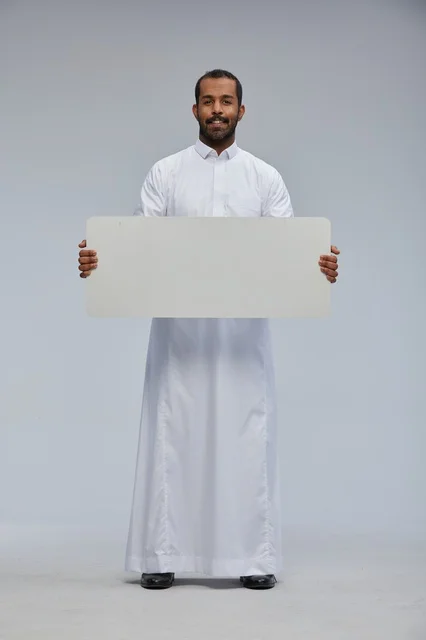 Saudi Man in Traditional Thobe Holding Blank Board