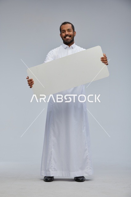 رجل سعودي بالثوب يحمل لوحة بيضاء فارغة