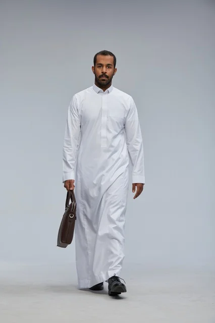 Saudi Businessman in Thobe Walking with Briefcase