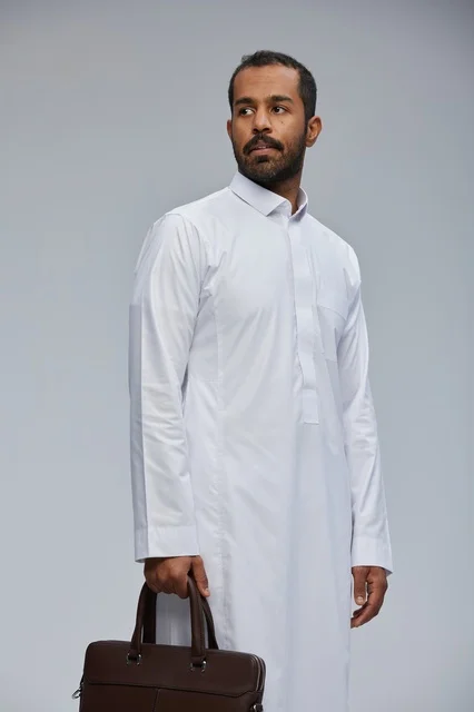 رجل أعمال سعودي بالثوب الأبيض يحمل حقيبة عمل