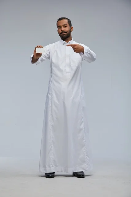 رجل سعودي بالثوب التقليدي يمسك بطاقة عمل فارغة
