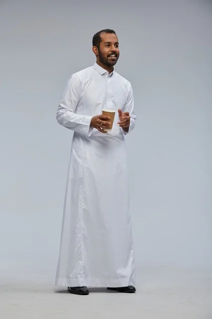 Smiling Saudi Man in White Thobe Holding Coffee Cup