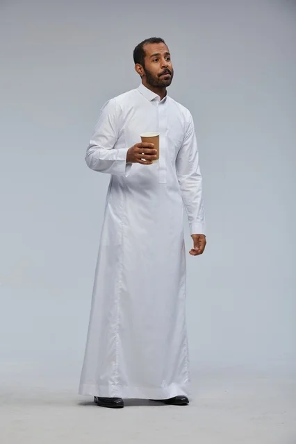 Saudi Man in White Thobe Holding Coffee Cup