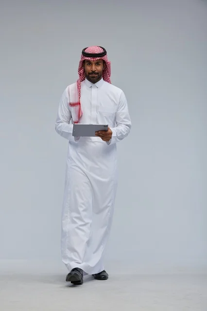 Saudi Man in Traditional Dress Using Tablet in Studio