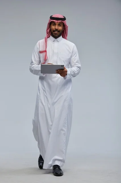 Saudi Man in Traditional Thobe Holding Tablet