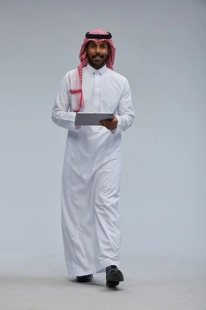Saudi man using tablet in traditional attire