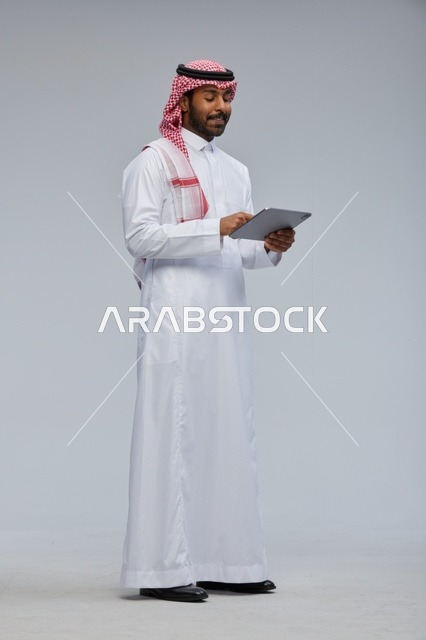 Saudi Man Using Digital Tablet in Traditional Dress