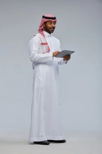 Saudi Man Using Digital Tablet in Traditional Dress
