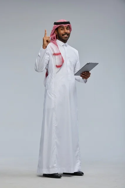 Saudi Man in Traditional Thobe with Tablet in Studio