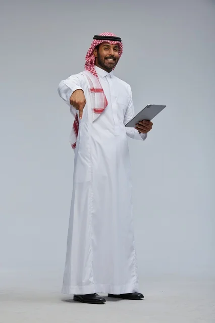 Saudi Man in Traditional Thobe Holding Tablet Pointing