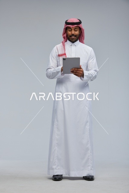 Saudi Man Using Digital Tablet in Traditional Thobe