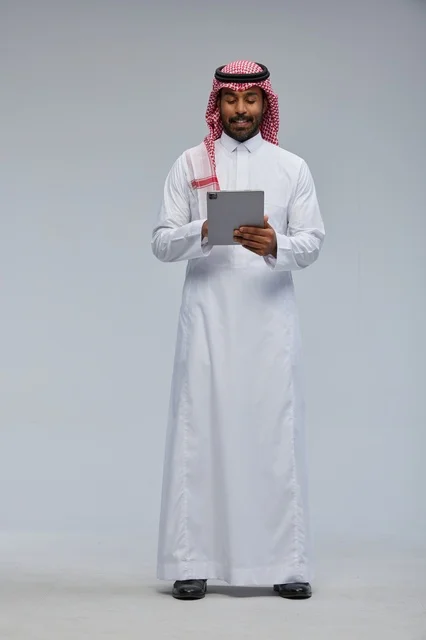 Saudi Man Using Digital Tablet in Traditional Thobe