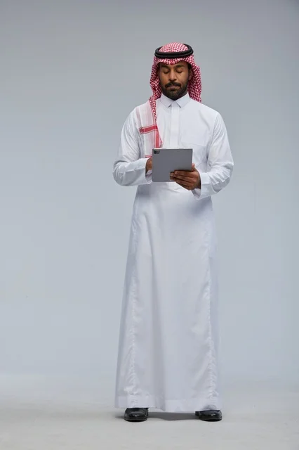 Saudi Man in Traditional Dress Using Tablet Studio Shot