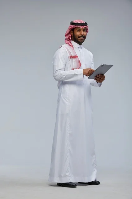 Saudi Man in Traditional Dress Using Digital Tablet