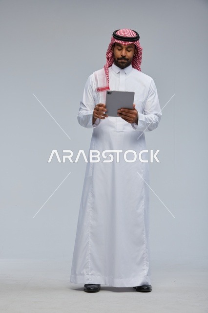 Saudi Man Using Digital Tablet in Traditional Thobe