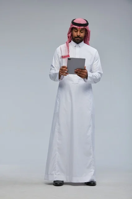 Saudi Man Using Digital Tablet in Traditional Thobe