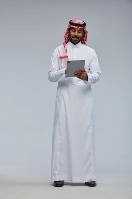 Saudi Man in Traditional Dress Using Tablet in Studio