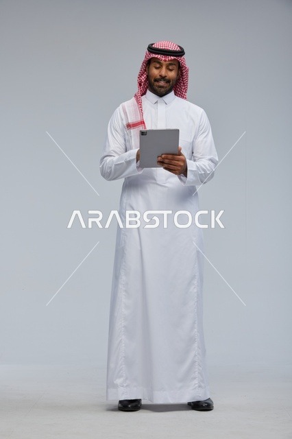 Saudi Man Using Digital Tablet in Traditional Dress
