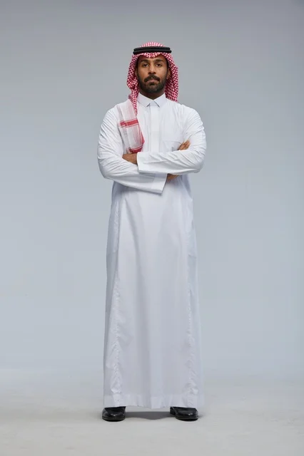 Smiling Saudi man in traditional attire with crossed arms