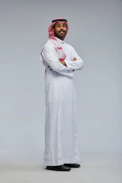 رجل سعودي مبتسم بالزي التقليدي في الاستوديو