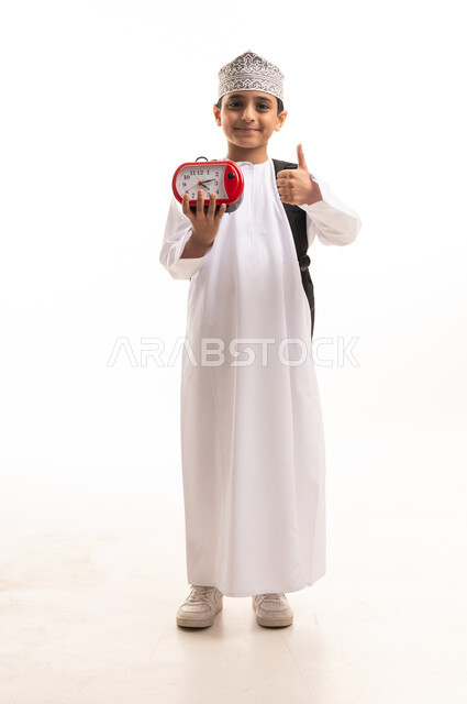 Omani Student in Traditional Dress with Alarm Clock