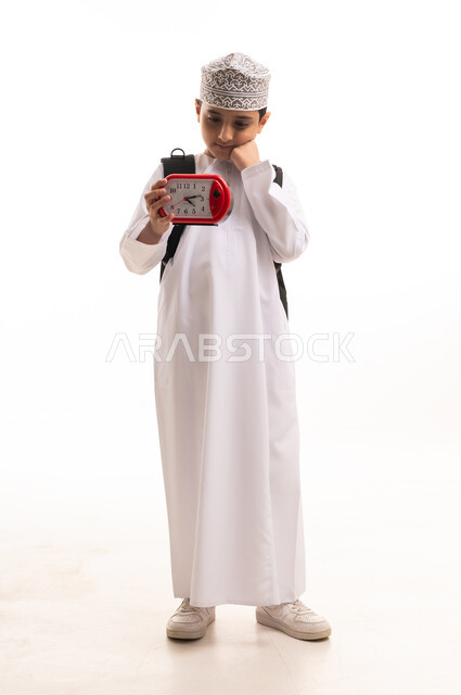 Omani Boy with School Backpack Holding Alarm Clock