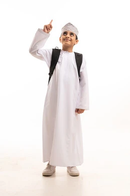 طالب عماني بالزي التقليدي يشير إلى الأعلى