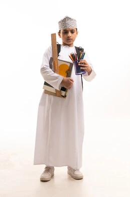 طالب عماني باللباس التقليدي مع أدوات الرسم الهندسية