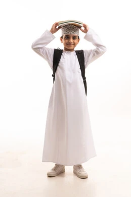 Omani Schoolboy in Traditional Dishdasha with Books