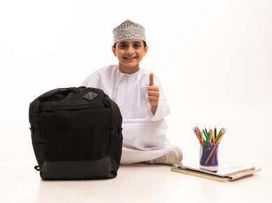 Omani Student with School Supplies and Thumbs Up