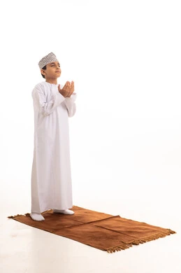 Omani Boy Praying in Traditional Dishdasha and Kumma