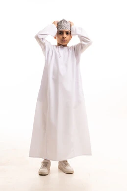 Omani Boy in Traditional Dishdasha and Kumma Cap
