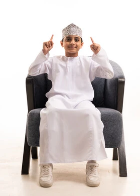 Omani Boy in Traditional Dress Pointing Upward