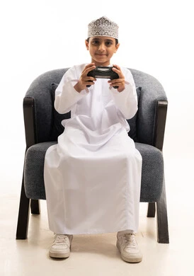 Omani Boy Playing Video Games in Traditional Dishdasha