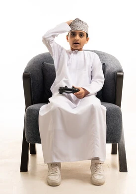 Omani Boy with Gaming Controller in Traditional Dress