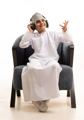 Omani Boy Wearing Headphones in Traditional Dress